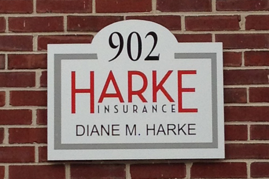 About Our Agency - Close Up View of Signage of Harke Insurance Agency on Brick Wall